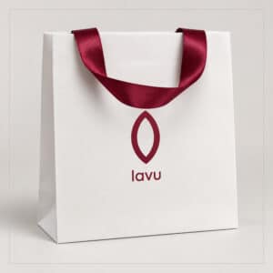 Biała torba papierowa z bordowym logo Lavu i satynowym uchwytem